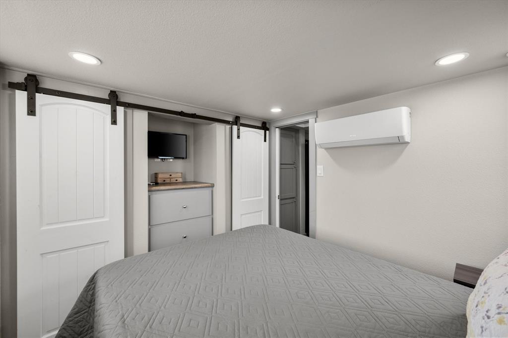 6388 Peninsula Road Kerens, TX 75144 - Photo 15 of 38 a bedroom with a bed and a refrigerator