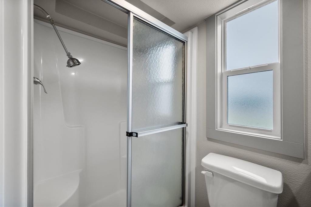 6388 Peninsula Road Kerens, TX 75144 - Photo 17 of 38 a bathroom with a toilet and a shower