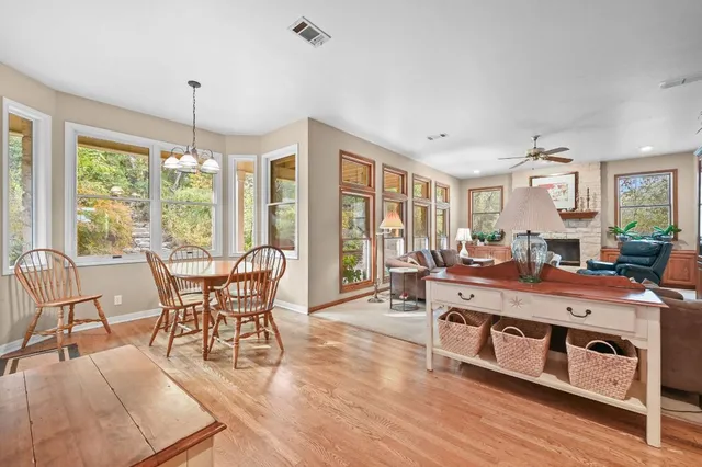 a kitchen with stainless steel appliances granite countertop a table chairs refrigerator and microwave