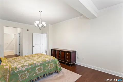 a spacious bedroom with a bed and a chandelier