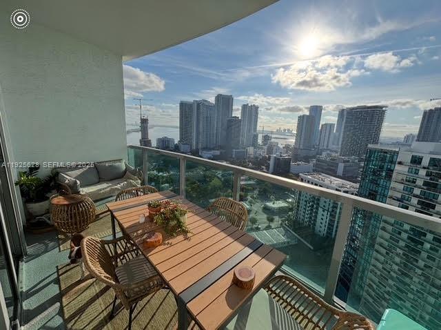 3301 Northeast 1st Avenue, Unit H2606 Miami, FL 33137 - Photo 5 of 31 a balcony with wooden floor and outdoor seating