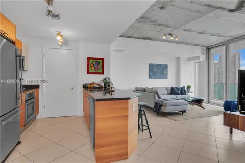 a large living room with stainless steel appliances kitchen island granite countertop a large counter top and couches