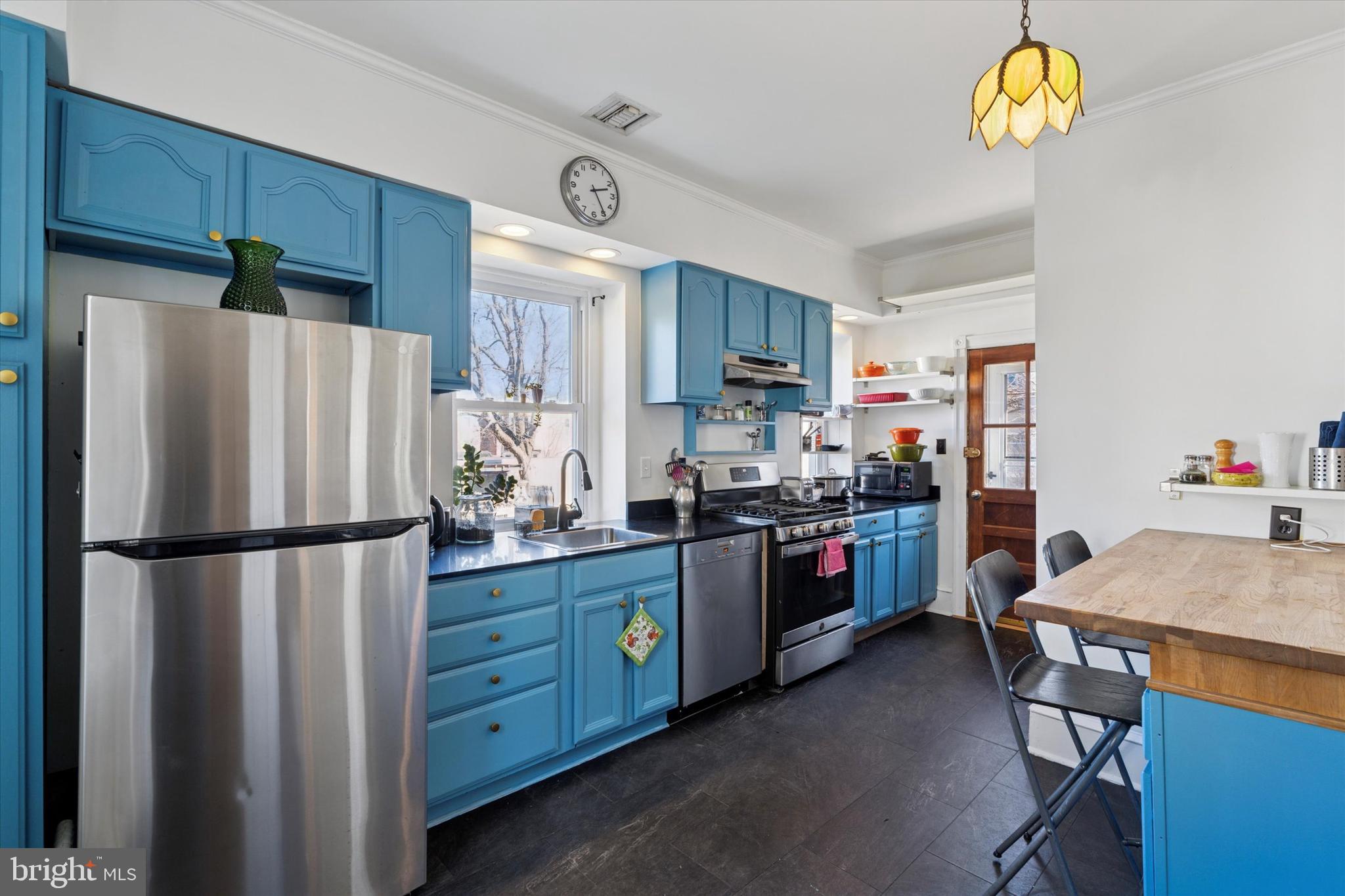 305 Grayling Avenue Narberth, PA 19072 - Photo 16 of 40 a kitchen with stainless steel appliances granite countertop a refrigerator a stove a sink a dining table and chairs with wooden floor
