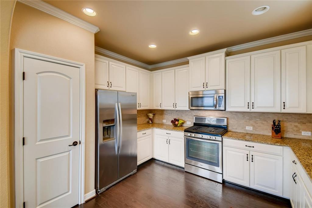 11929 Terraza Circle, Unit TH37 Austin, TX 78726 - Photo 5 of 17 a kitchen with stainless steel appliances granite countertop a refrigerator sink and white cabinets