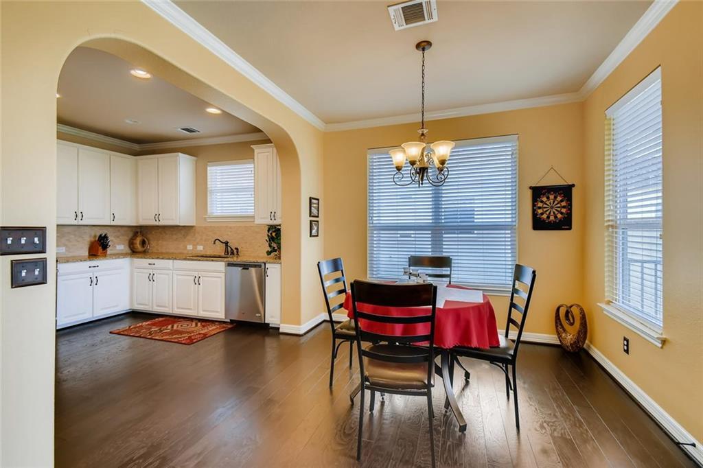 11929 Terraza Circle, Unit TH37 Austin, TX 78726 - Photo 8 of 17 a kitchen that has a table chairs in it and wooden floors
