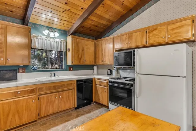 a kitchen with a sink a refrigerator and cabinets