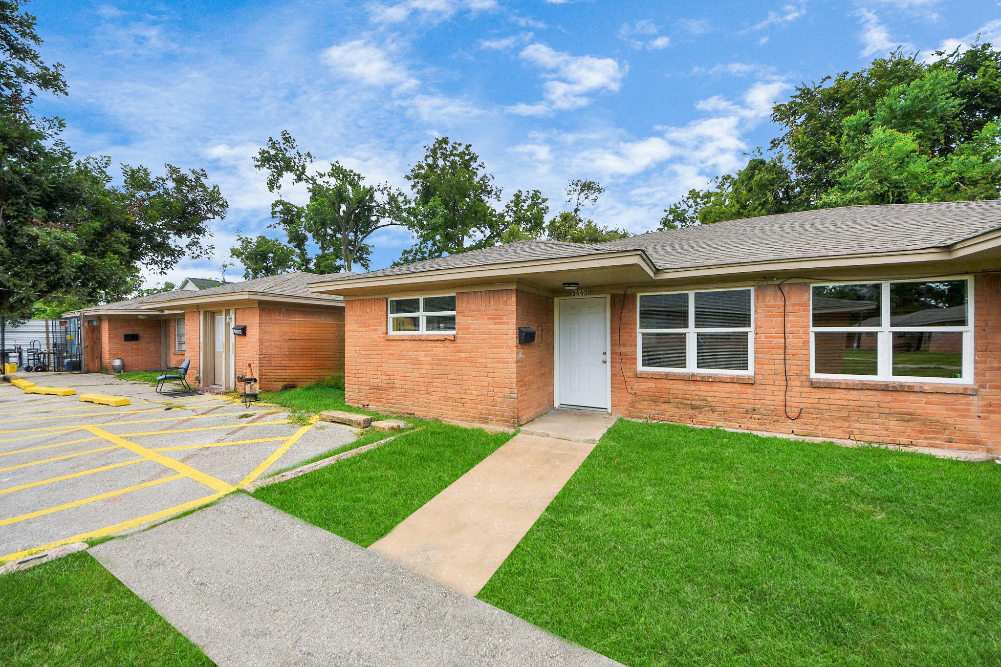 a view of a yard in front of a house with a large tree