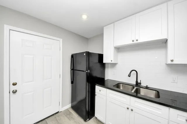 a kitchen with a refrigerator and a sink