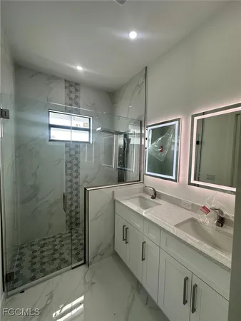 a bathroom with a granite countertop sink mirror and shower