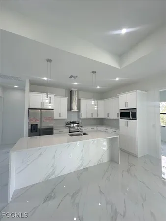 a large kitchen with a large counter top stainless steel appliances and cabinets