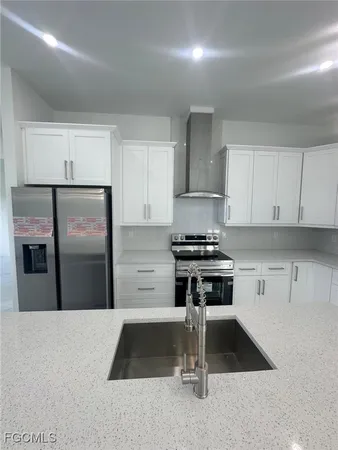 a kitchen with a refrigerator and white cabinets