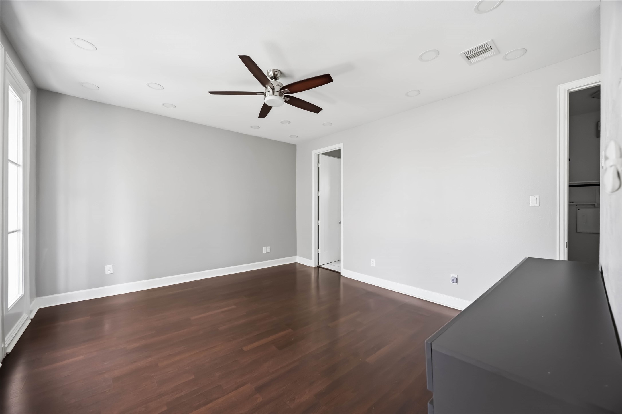 708 Schwartz Street Houston, TX 77020 - Photo 8 of 25 an empty room with wooden floor a ceiling fan and windows