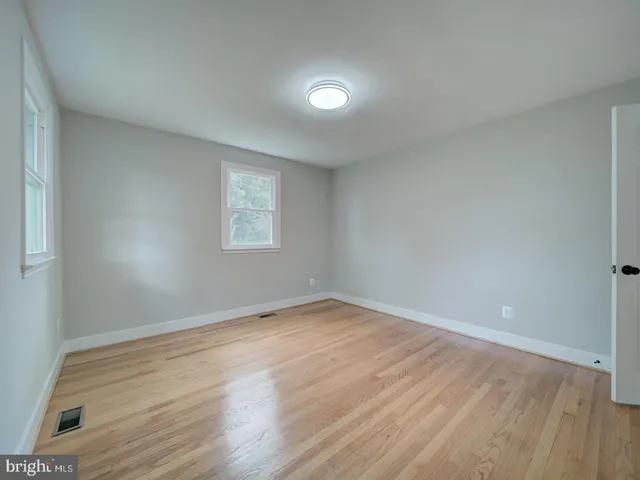 a view of empty room with wooden floor and fireplace