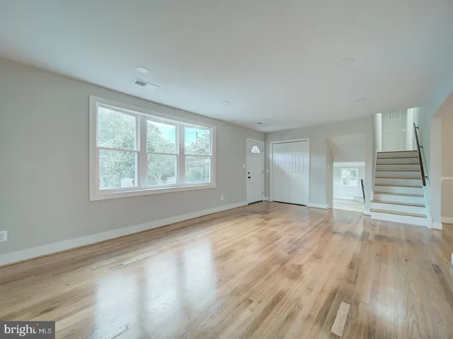 a view of a kitchen with wooden floor and windows