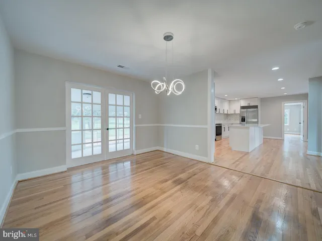 a large kitchen with kitchen island a sink a center island stainless steel appliances and a window