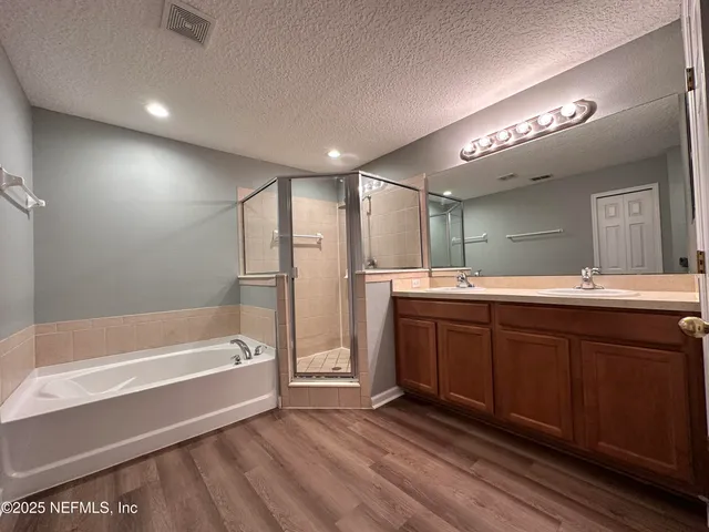 a spacious bathroom with a tub sink and mirror