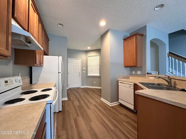 a kitchen with granite countertop a sink stove and refrigerator