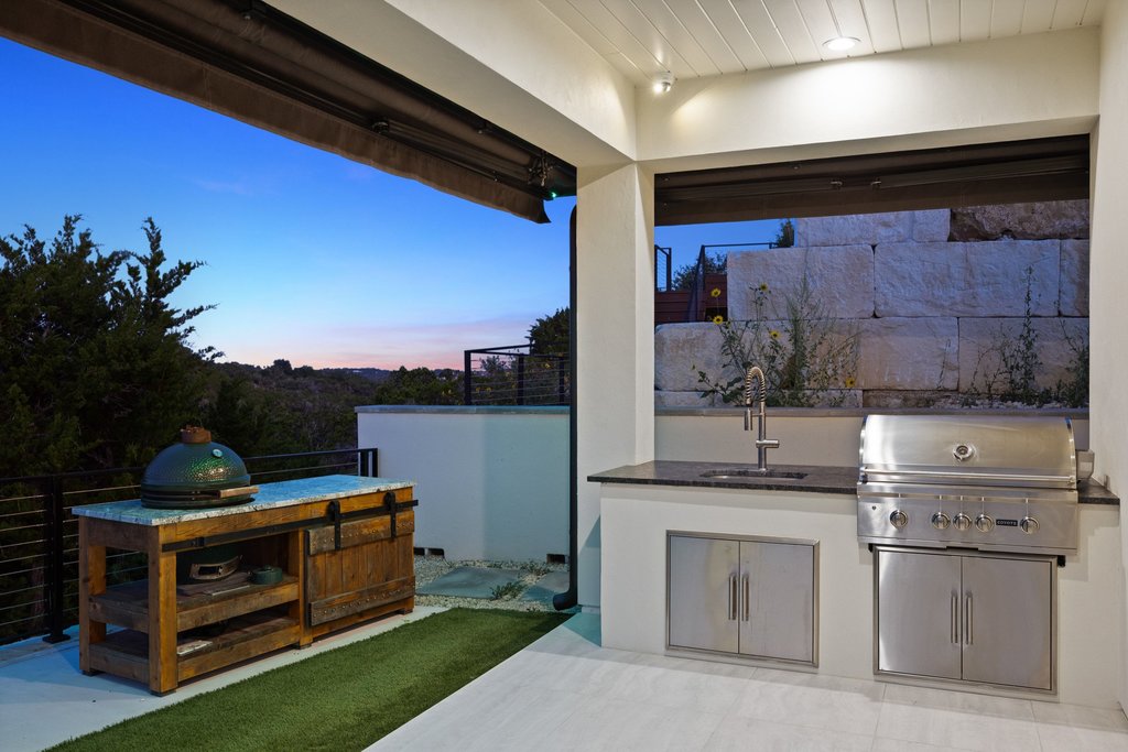 7117 Davenport Divide Road Austin, TX 78738 - Photo 15 of 40 An outdoor kitchen, complete with a built-in grill and sink, offers picturesque views of the surrounding landscape.