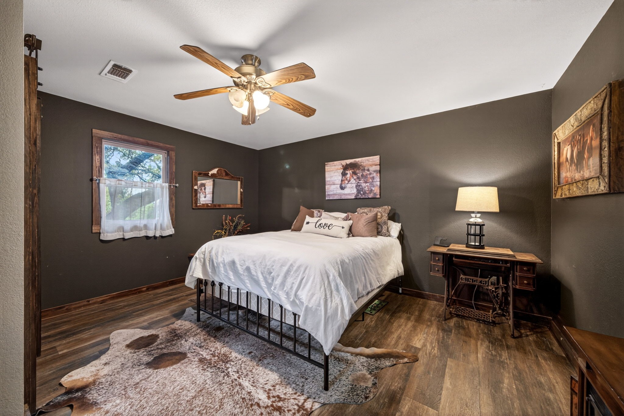 1850 Ranch Road 337 Leakey, TX 78873 - Photo 22 of 50 Spacious living area featuring updated flooring and a wood-burning fireplace for cozy Hill Country evenings