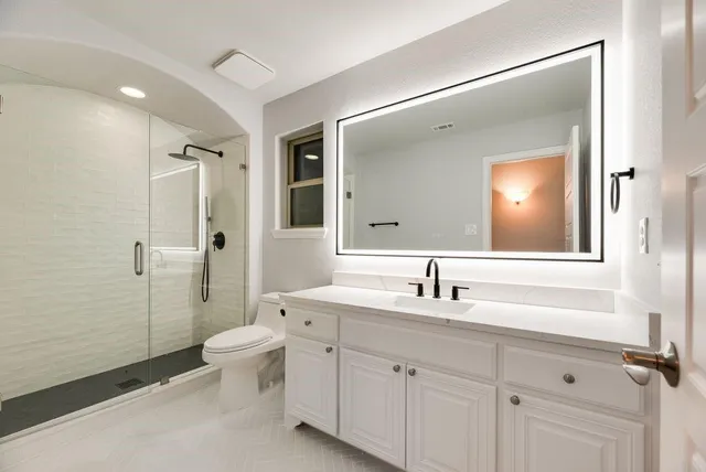 a large room with chandelier fan and windows