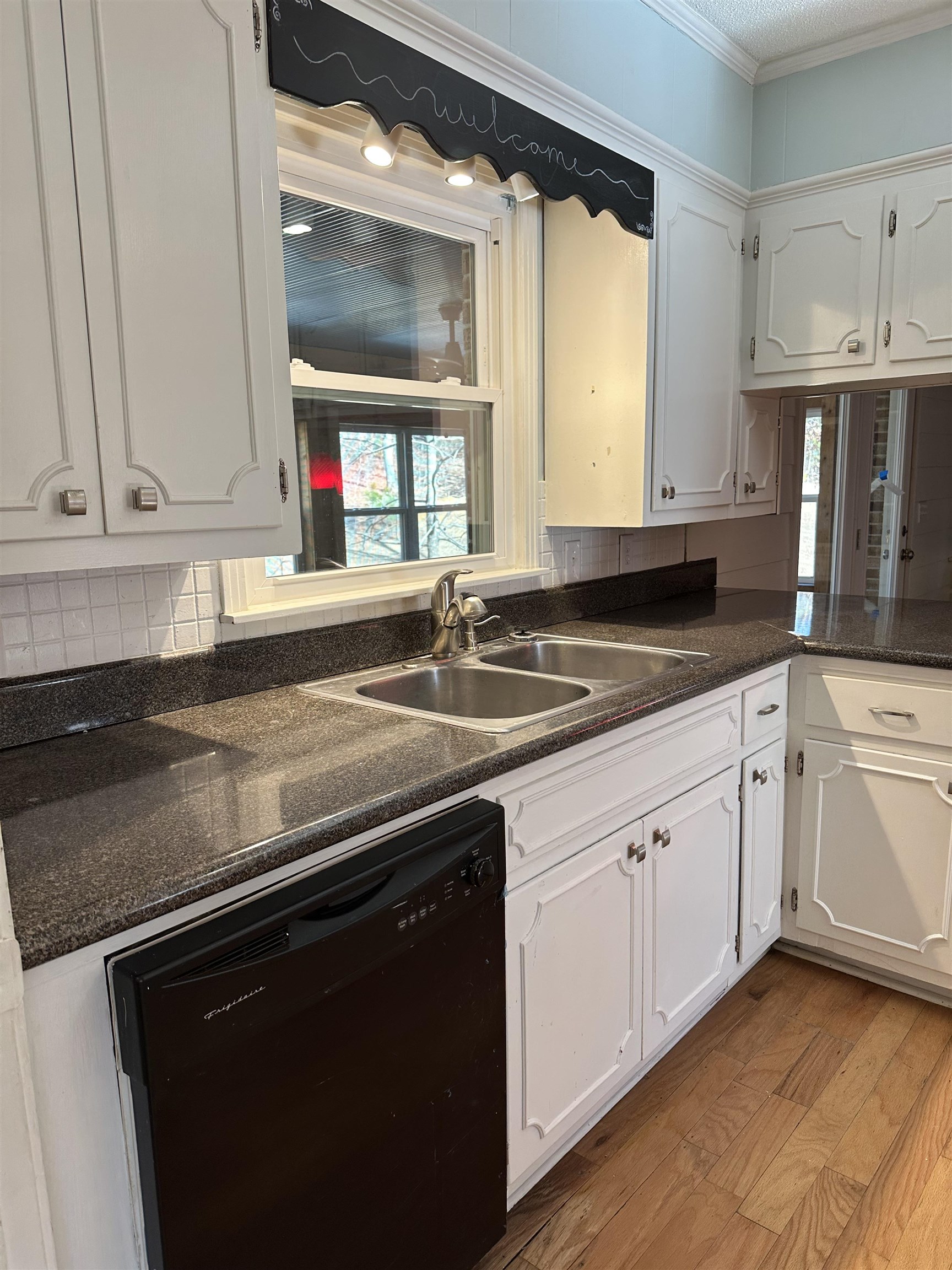 141 Pecan Street Selmer, TN 38375 - Photo 10 of 35 a kitchen with granite countertop a sink stainless steel appliances white cabinets and a window