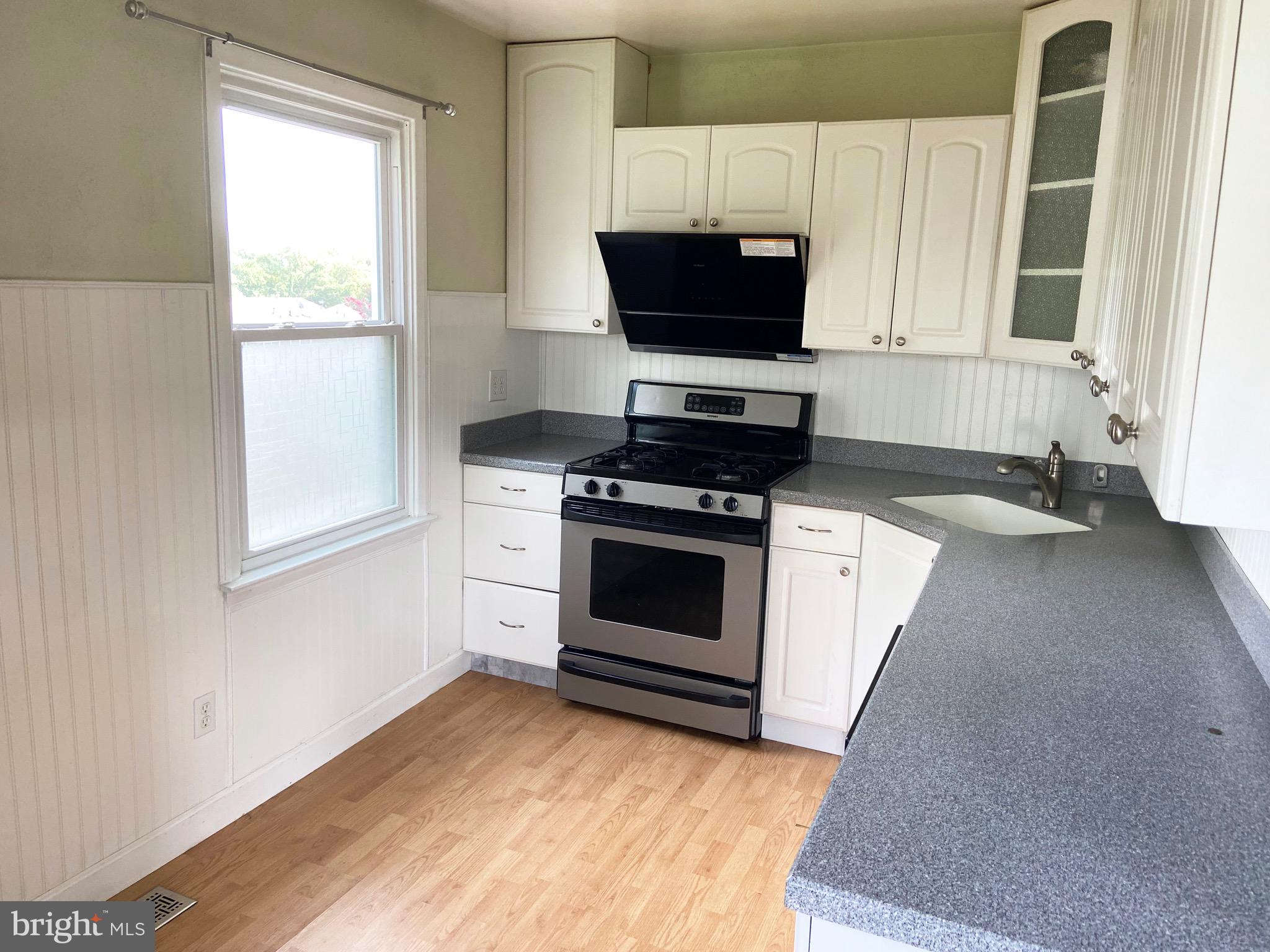 8549 Ramort Drive, Unit 23A Nottingham, MD 21236 - Photo 5 of 18 a kitchen with a stove a sink and a window