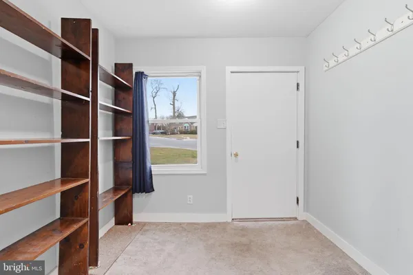 a view of an empty room with cabinet and a window