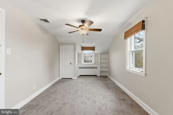 a view of a livingroom with a ceiling fan and window