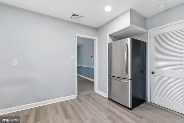 a view of empty room with wooden floor and cabinets
