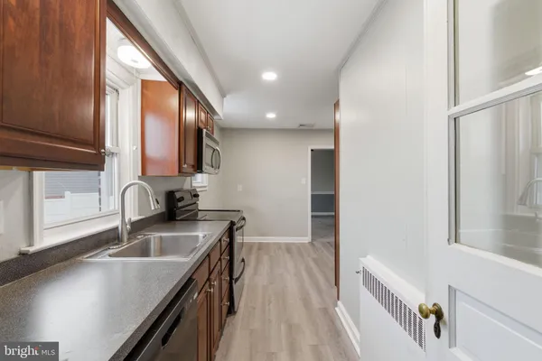 a kitchen with a sink a stove and a microwave oven