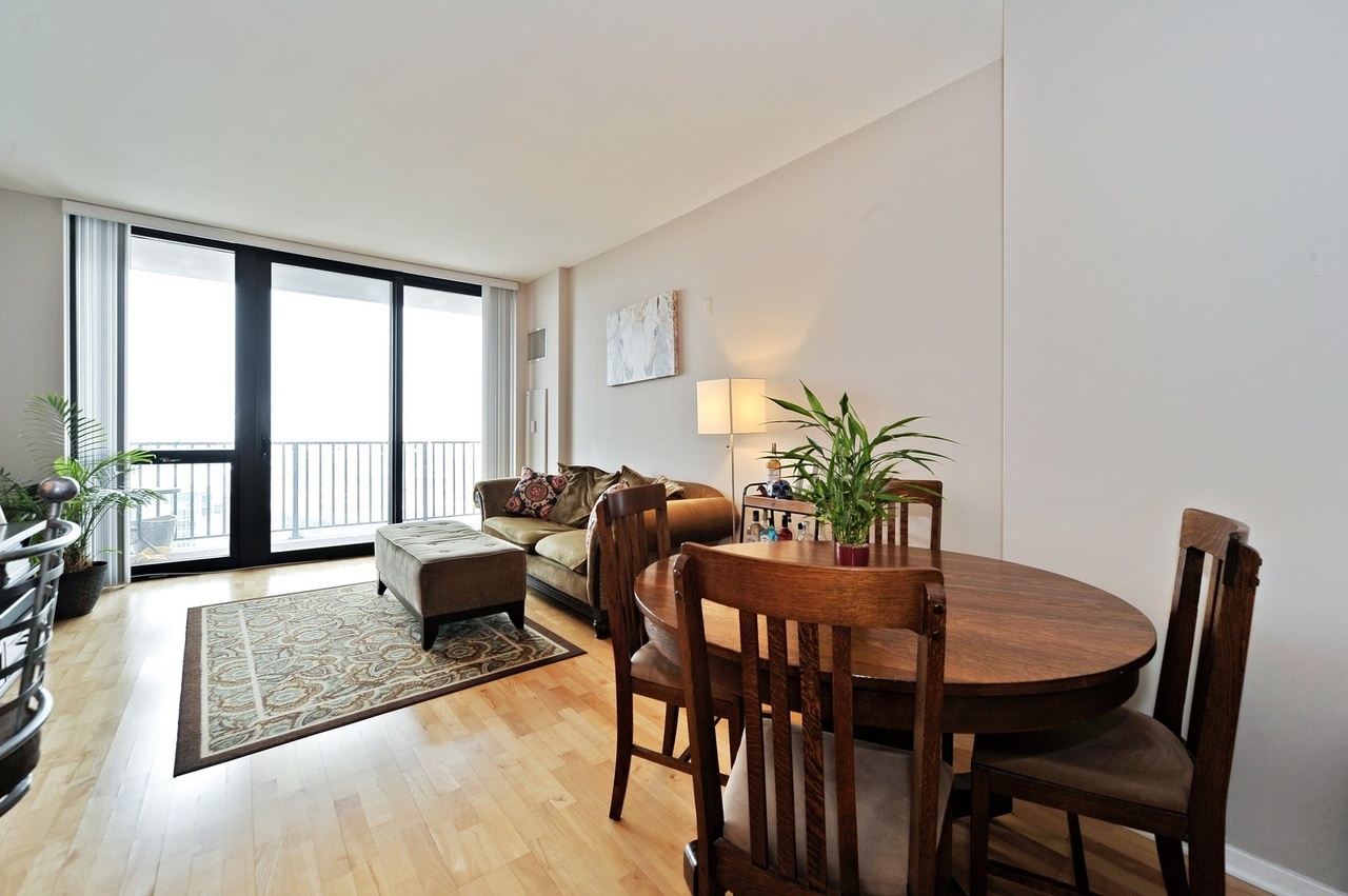 210 South Desplaines Street, Unit 2104 Chicago, IL 60661 - Photo 4 of 9 a view of a dining room with furniture large windows and wooden floor