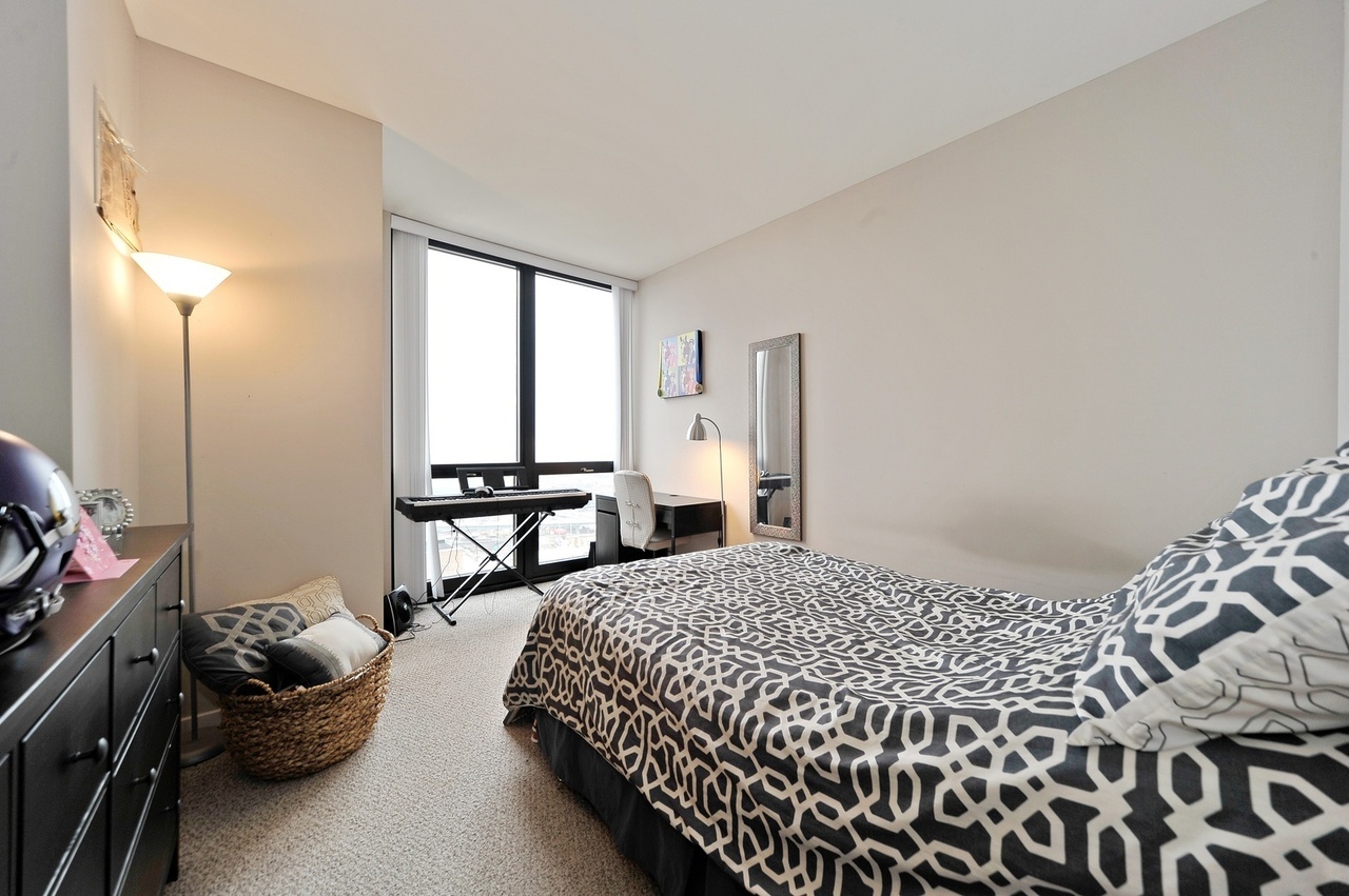 210 South Desplaines Street, Unit 2104 Chicago, IL 60661 - Photo 7 of 9 a bedroom with a bed and a window