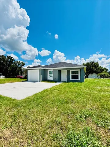 a front view of a house with yard and green space