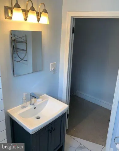 a bathroom with a sink vanity and a mirror