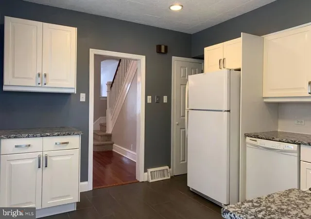 a white refrigerator freezer and a stove sitting inside of a kitchen
