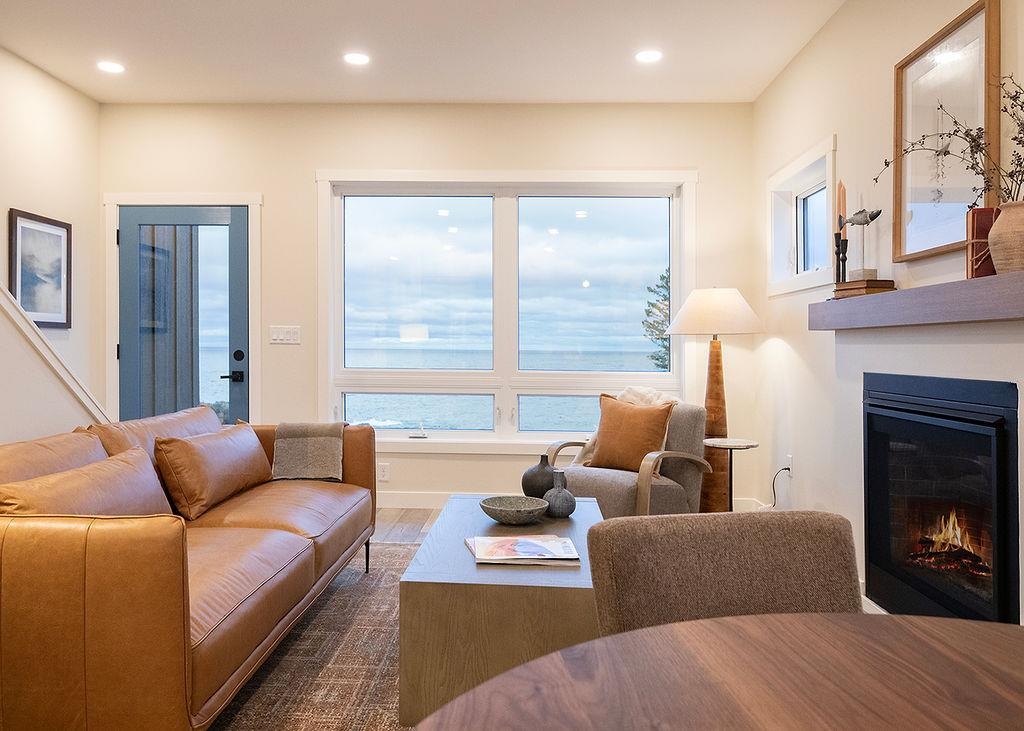 Living room featuring a glass covered fireplace, recessed lighting, and wood finished floors