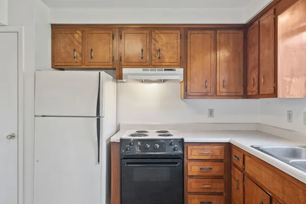 a kitchen with a refrigerator sink and cabinets