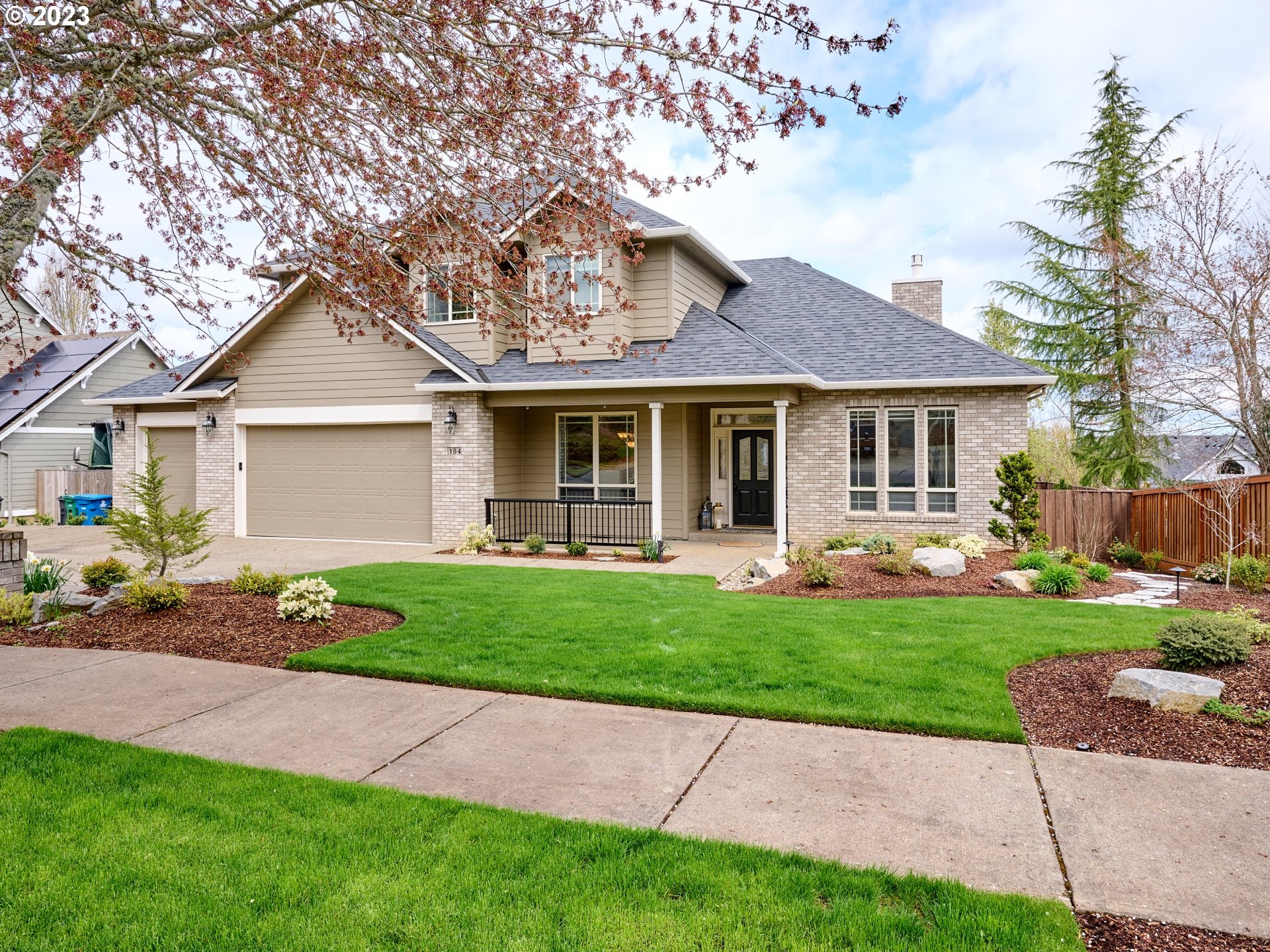 a front view of a house with a garden and yard