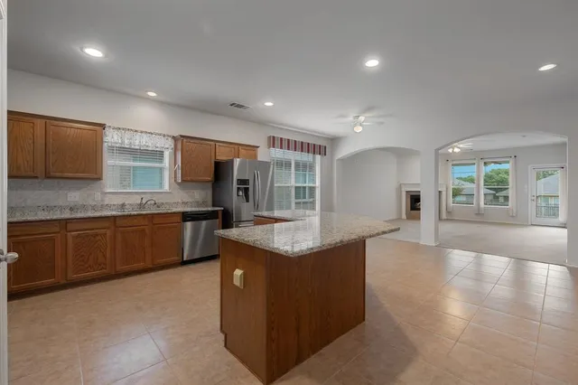 a kitchen with stainless steel appliances granite countertop a sink counter space cabinets and a large window