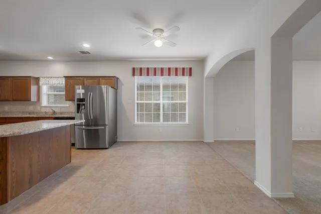 a view of kitchen with stainless steel appliances wooden floor and a window