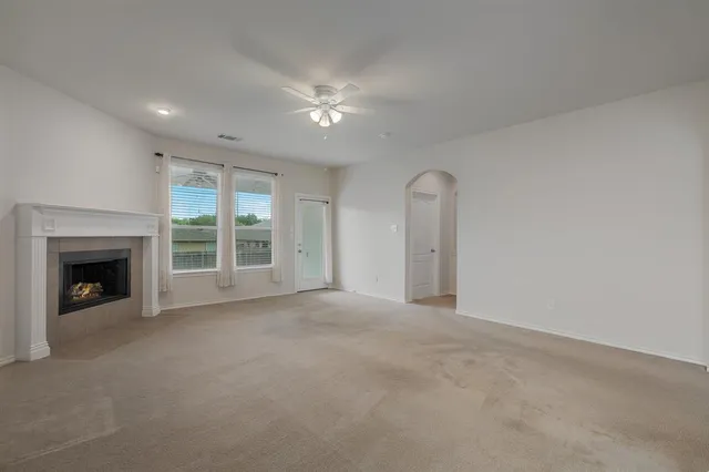 a view of an empty room with a fireplace and a window
