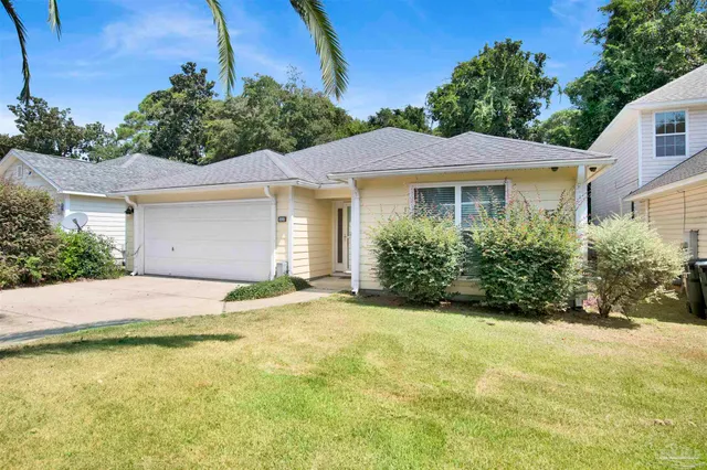 a view of a house with a yard and potted plants