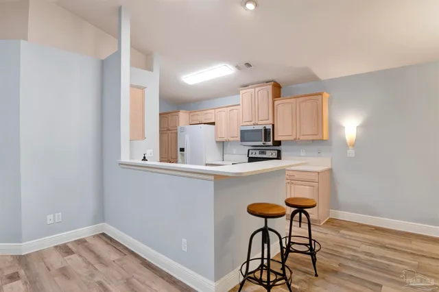 a kitchen with stainless steel appliances granite countertop a sink and a refrigerator