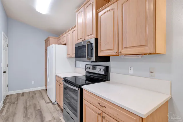 a kitchen with stainless steel appliances a refrigerator a stove a microwave and cabinets