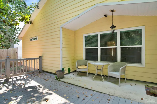 a view of a patio with table and chairs and wooden fence