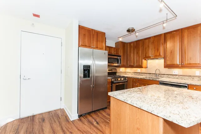 a kitchen with granite countertop a refrigerator and a sink