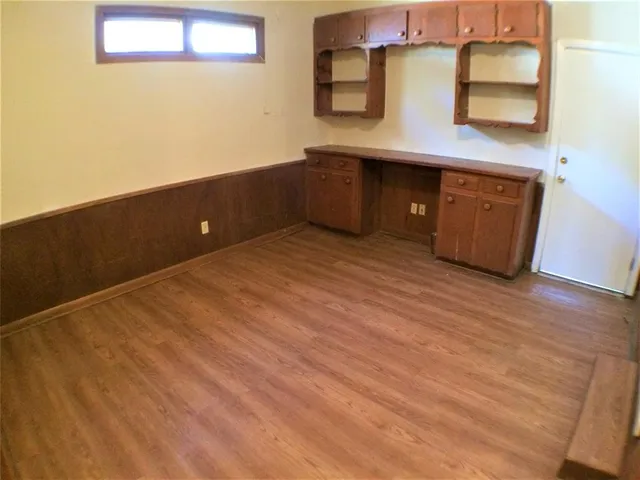 a kitchen with a wooden floor and cabinets