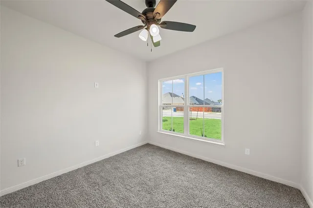 an empty room with a window and a fan