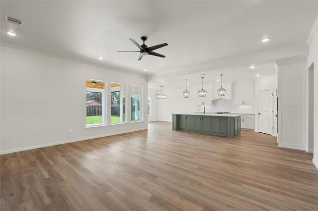a view of a kitchen with wooden floor and a ceiling fan