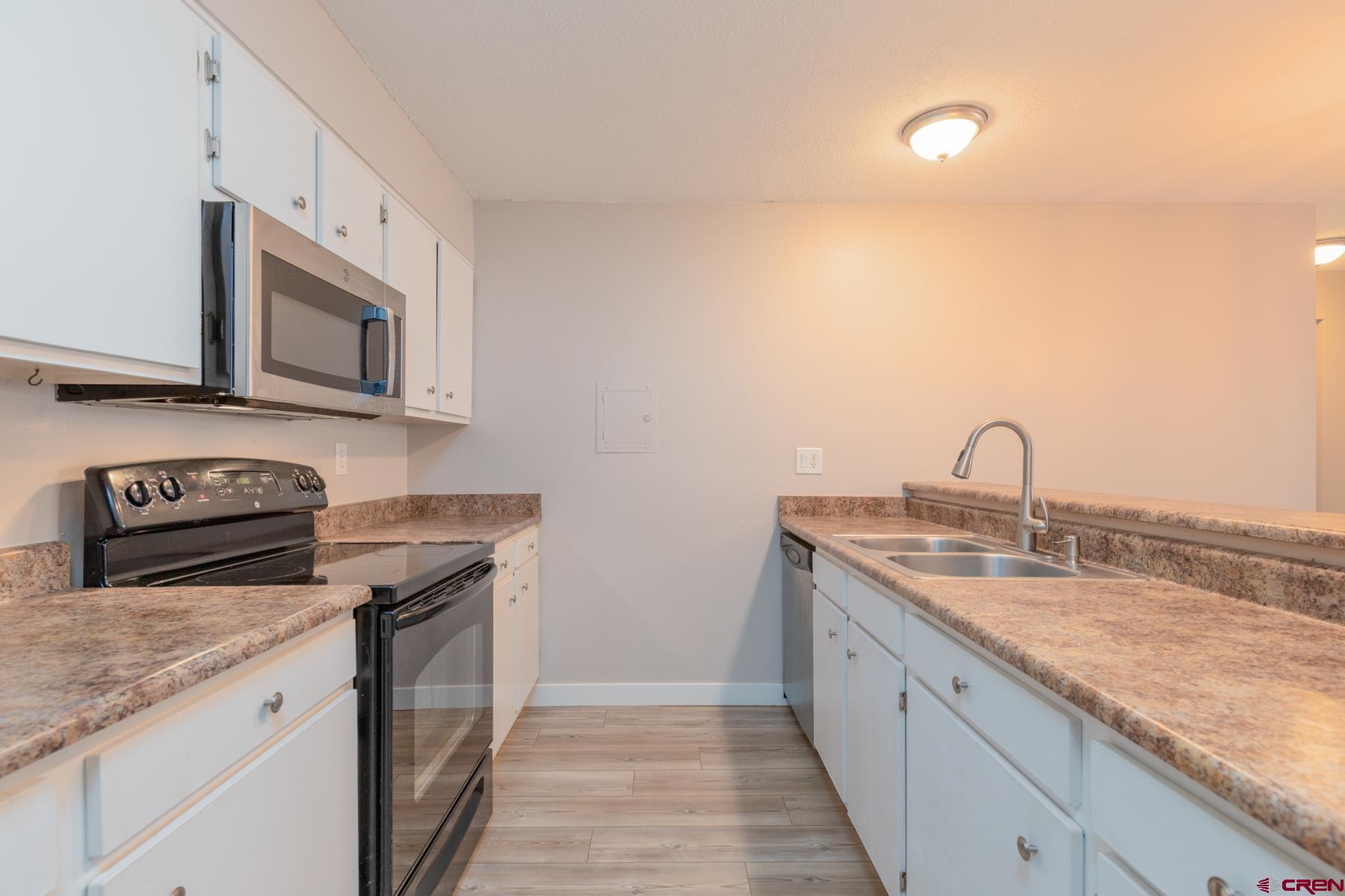 1135 Florida Road, Unit B2 Durango, CO 81301 - Photo 4 of 26 a kitchen with granite countertop a sink stainless steel appliances and cabinets